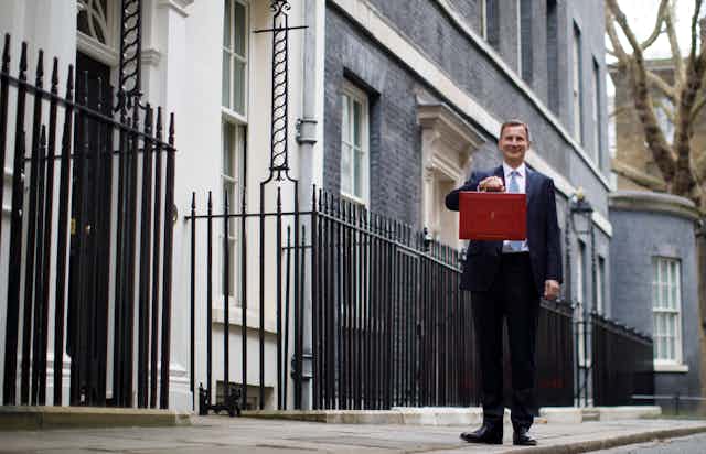 British Chancellor of Exchequer Jeremy Hunt poses with the Budget Box as he leaves 11 Downing Street before presenting the government's annual budget to Parliament in London, Britain, 15 March 2023. 