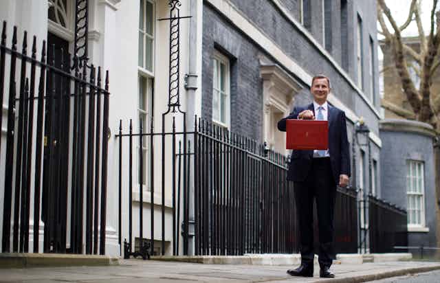 British Chancellor of Exchequer Jeremy Hunt poses with the Budget Box as he leaves 11 Downing Street before presenting the government's annual budget to Parliament in London, Britain, 15 March 2023.