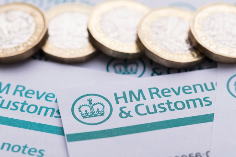 HMRC Her Majesty's Revenue and Customs tax paperwork and pound coins, sterling, gbp, business taxes