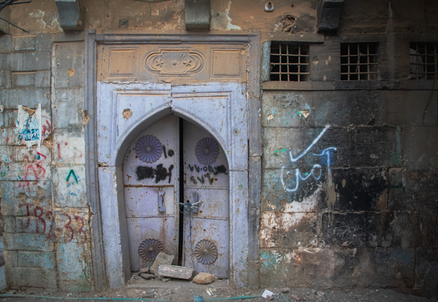 a graffitied door in an old Arabic architectural style