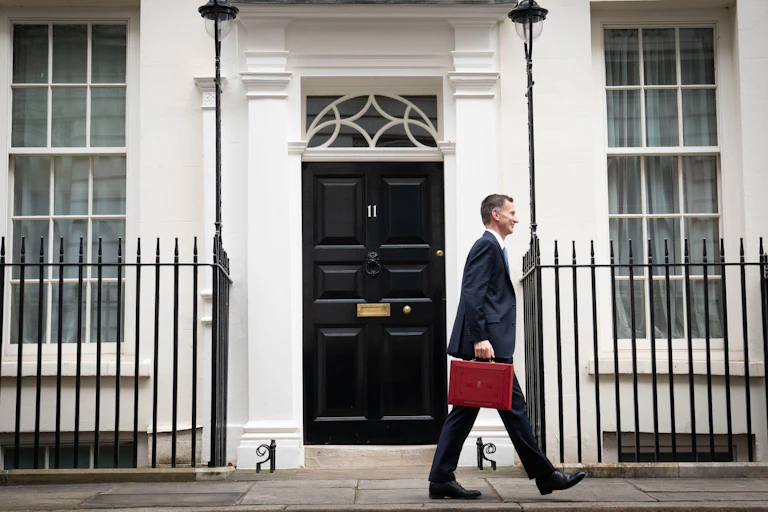 Jeremy Hunt walking past 11 Downing Street with his red ministerial box in hand.