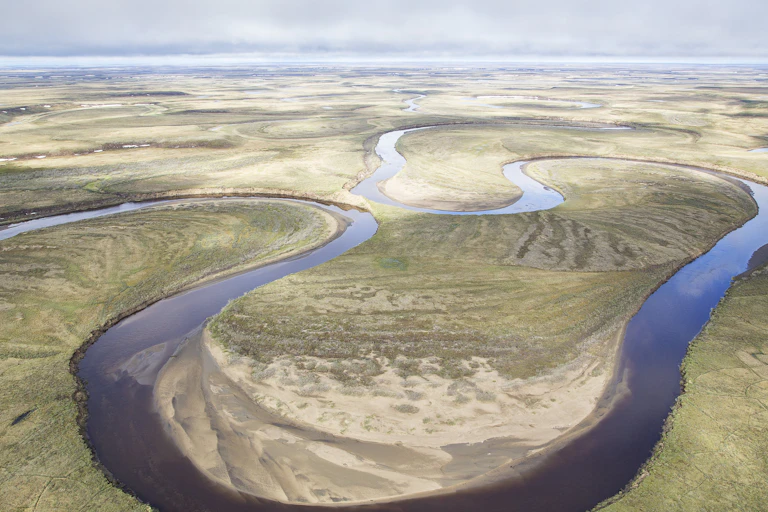 A river meanders through an wide open landscape of grasslands