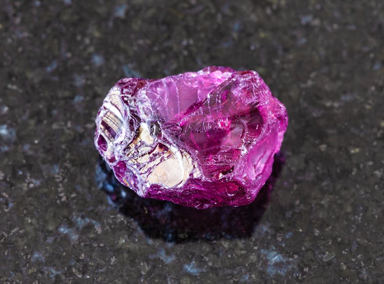 A bright purple pyrope garnet against a great background.