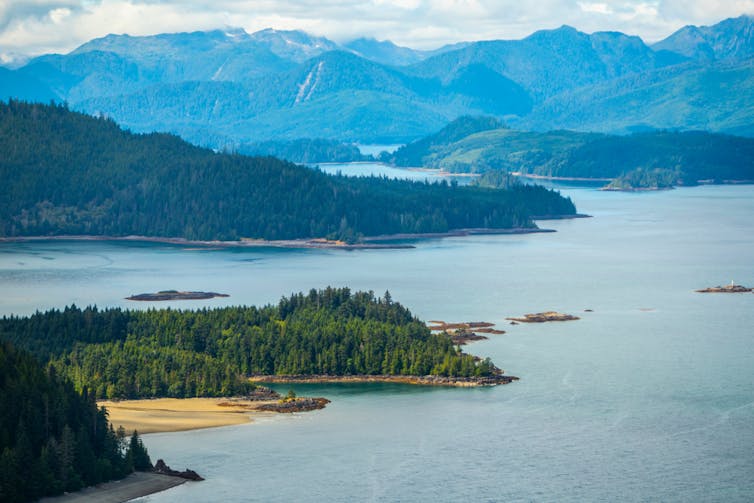 Islands surrounded by water are seen in the foreground. Mountains are in the background.