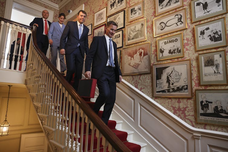Jeremy Hunt and his team walking down the stairs of 11 Downing Street.