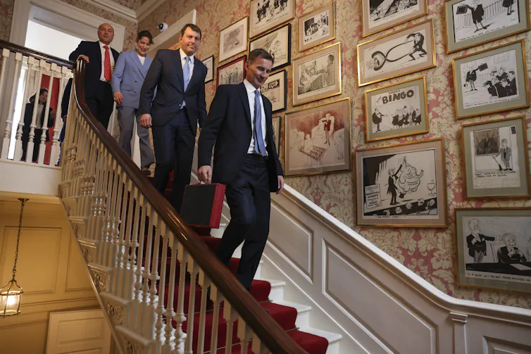 Jeremy Hunt and his team walking down the stairs of 11 Downing Street.