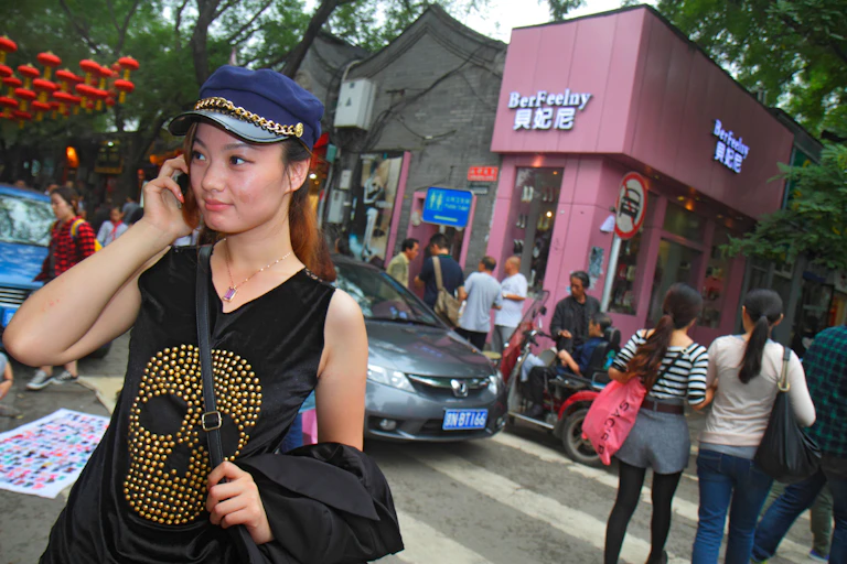 A woman with a blue cap on her phone.
