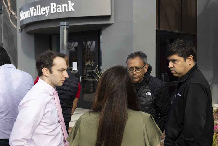 people stand outside a bank