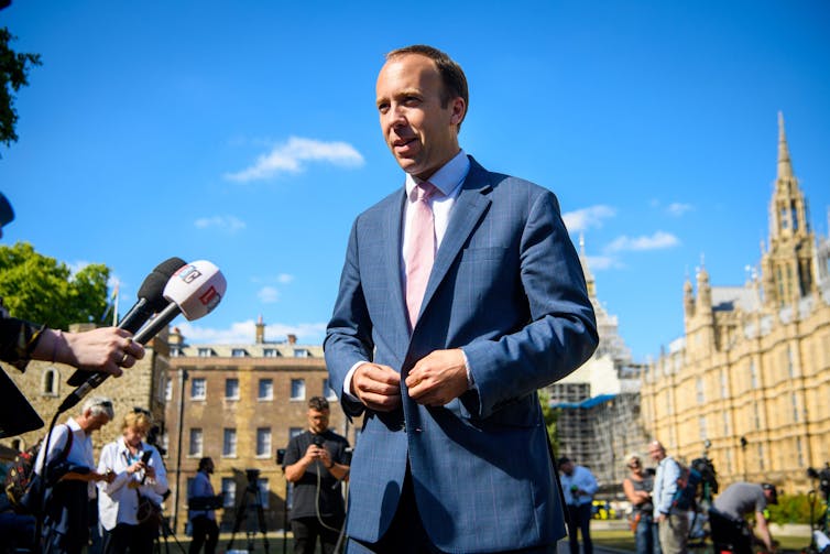 Matt Hancock talking into a microphone in front of parliament.