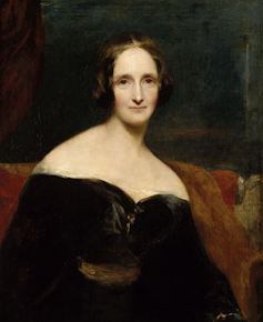 Mary Shelley looks at the viewer, with her black dress off her shoulders and hair tied back.