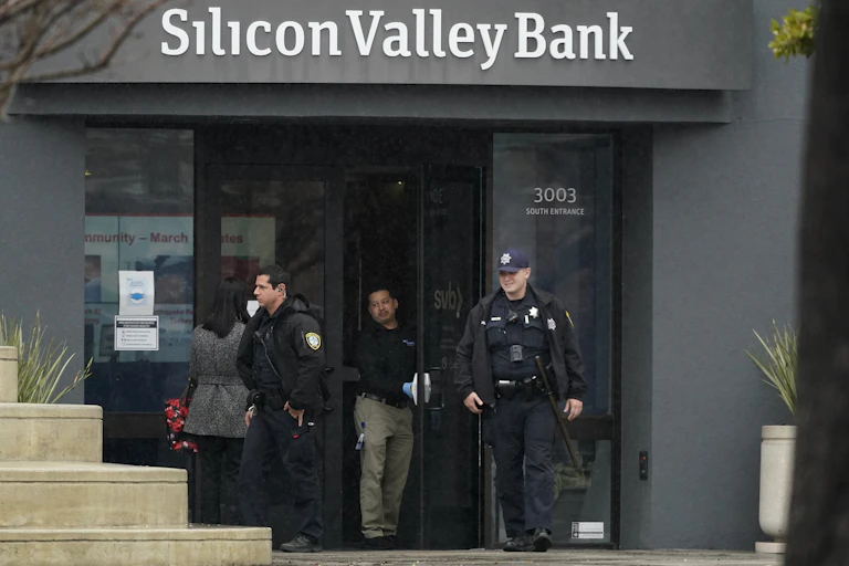 Two police officers exit a Silicon Valley Bank branch buliding