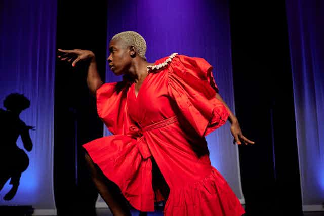 An African woman in a red dress dances
