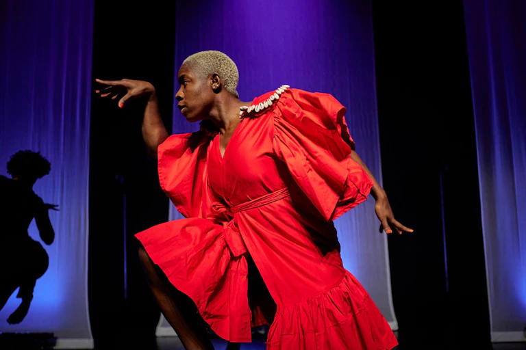An African woman in a red dress dances