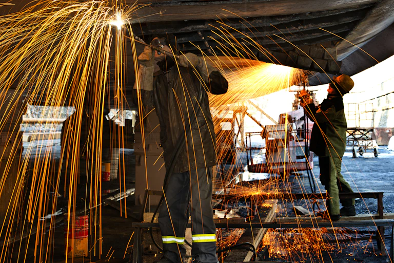 Welders working on a ship in drydock.