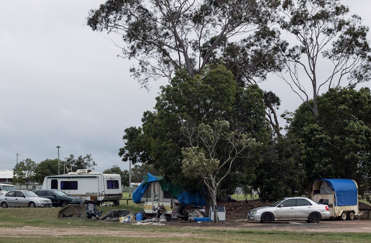 Caravans and cars under trees at the roadside