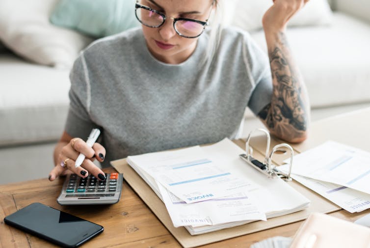 Woman with bills, calculator, working out finances