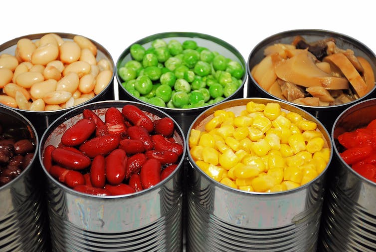 Un assortimento di verdure in scatola, tra cui fagioli rossi, piselli e mais.