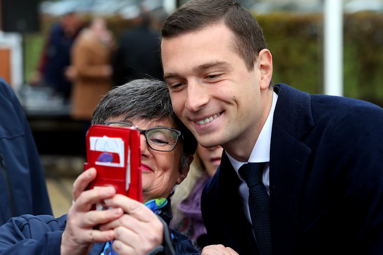 Jordan Bardella fait un selfie avec une passante