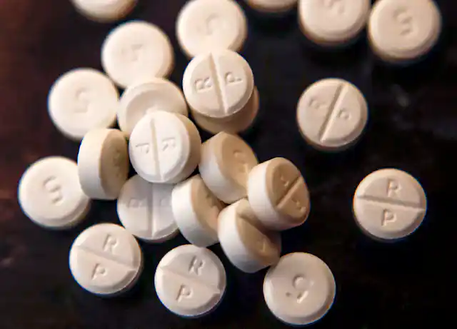 White pills on a dark surface.