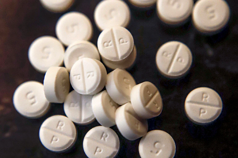 White pills on a dark surface.