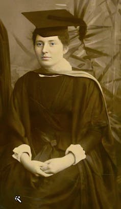 A young woman in a mortar board hat and gown.