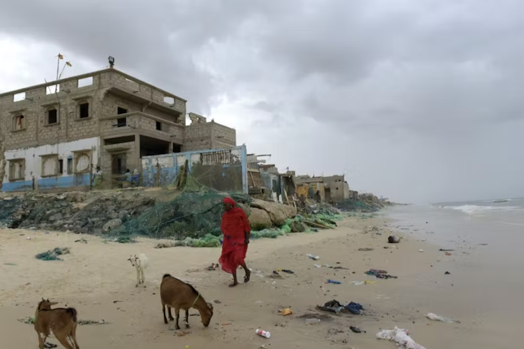 personne dans un paysage de maisons en ruine au bord de la mer