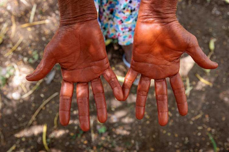 Hands covered in red ochre.