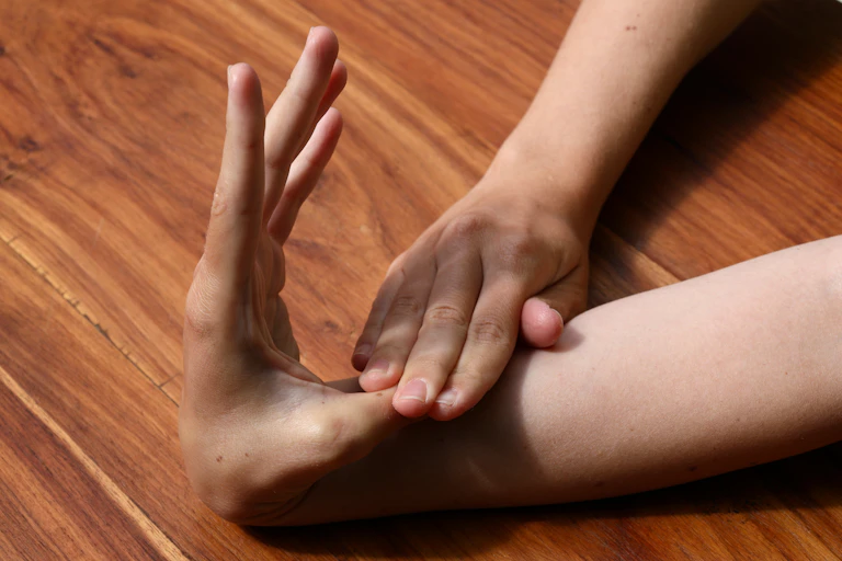 person bends thumb back to own arm