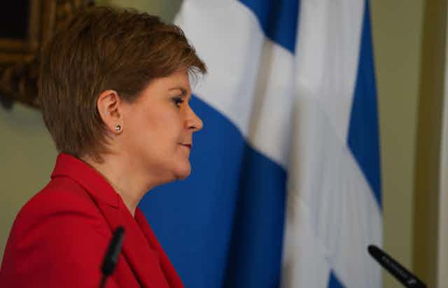 Nicola Sturgeon in front of a Scottish flag.