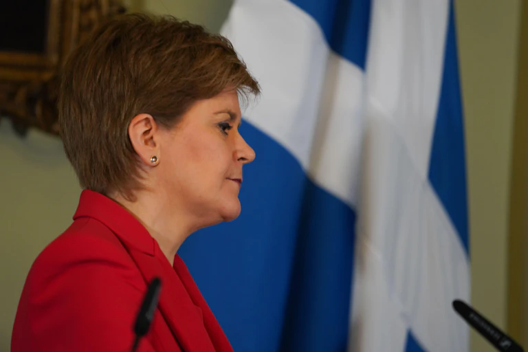 Nicola Sturgeon in front of a Scottish flag.