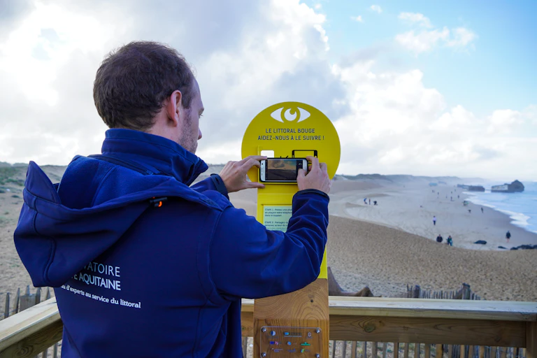 Un homme prend la côte landaise en photo depuis un poste installé sur la plage de Capbreton.