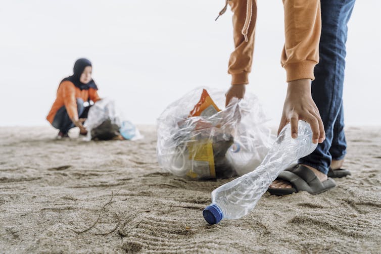 People clearing plastic from a beach during Ramadan
