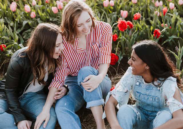 three young women laughing together
