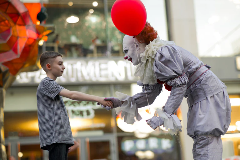 clown sert la main d'un enfant