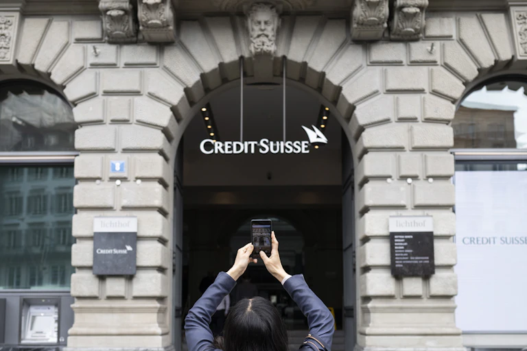 A woman takes photo of Credit Suisse bank branch in Zurich, Switzerland, March 20 2023.