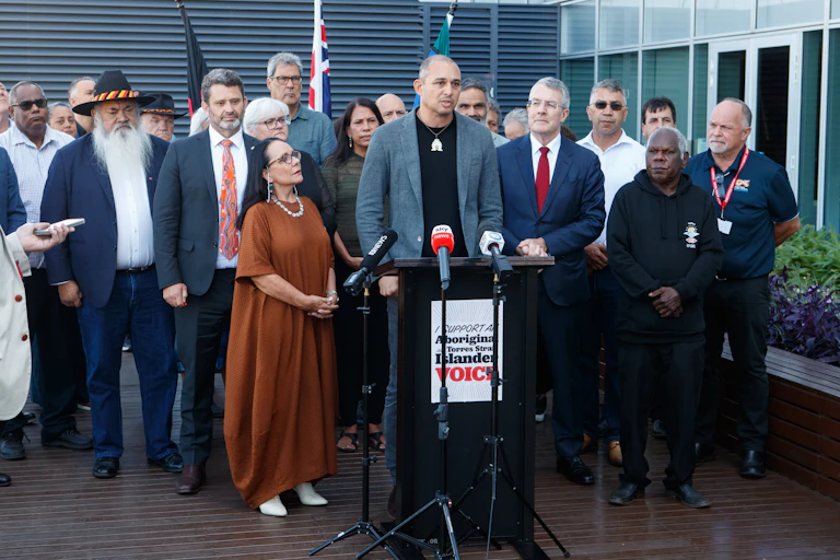 A group of people stand in front of a podium.