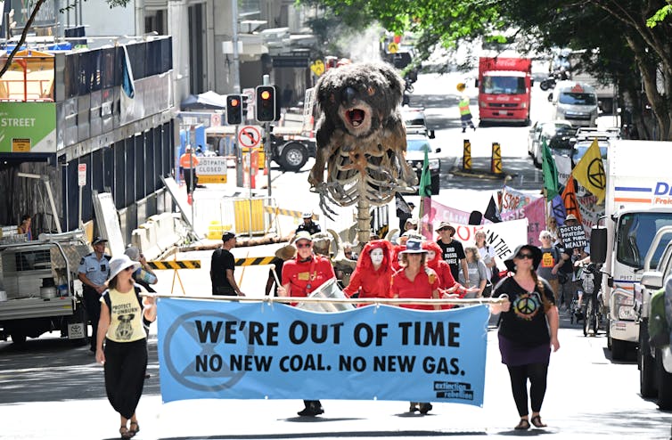 Extinction Rebellion protesters are seen pushing an animatronic burning Koala puppet called Blinky through the streets of the CBD in Brisbane, Wednesday, March 15, 2023