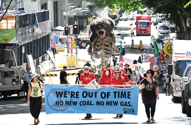 Extinction Rebellion protesters are seen pushing an animatronic burning Koala puppet called Blinky through the streets of the CBD in Brisbane, Wednesday, March 15, 2023