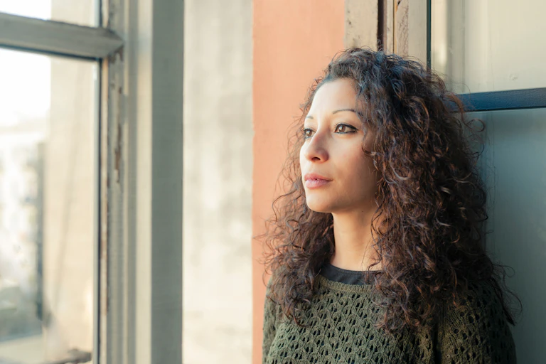 Woman leaning against a wall.