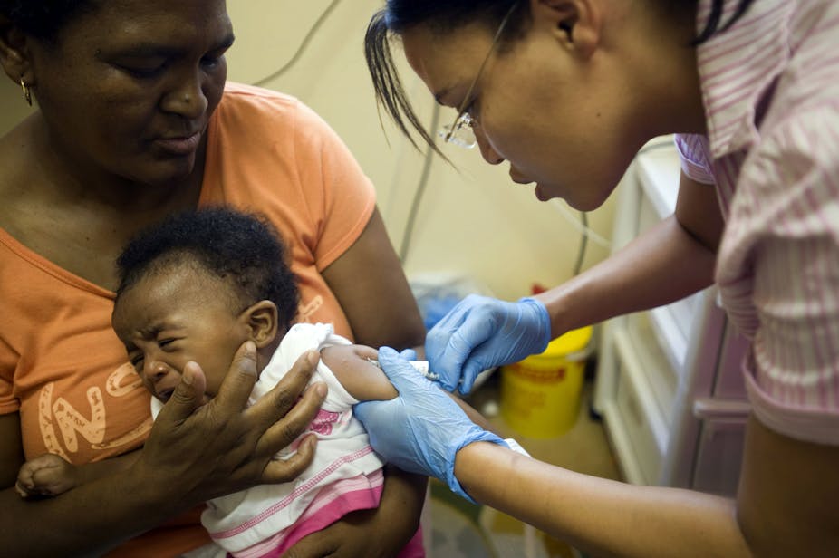 a nurse injecting a crying child 