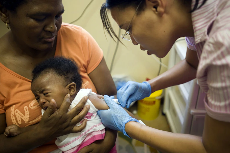 a nurse injecting a crying child