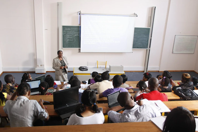 A woman teaching a group of men and women in a room