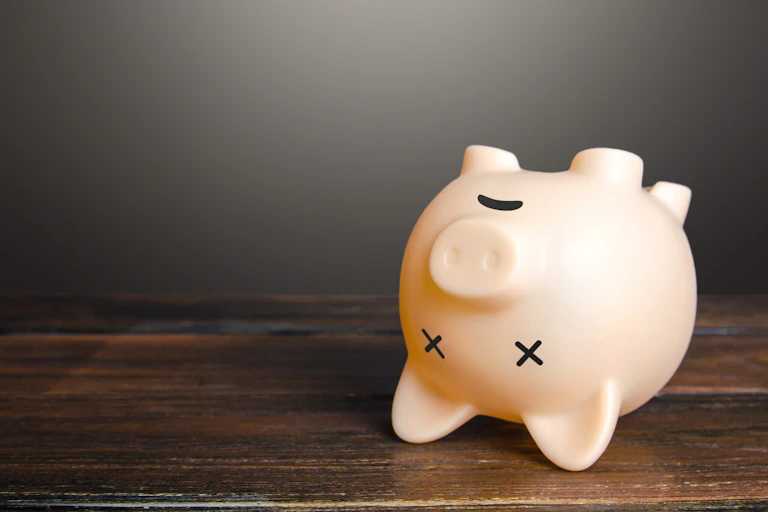 Dead piggy bank lies upside down. Economic depression. Financial crisis, end of savings, bankruptcy. Devaluation, inflation. Impoverishment. Refinancing restructuring of debts.