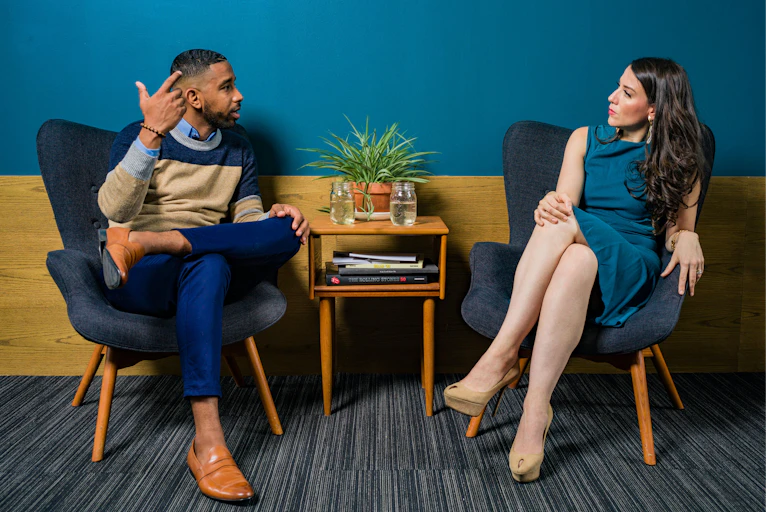 Man and woman sitting in chairs.