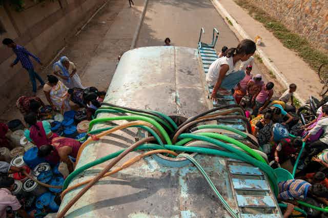 Personas recogiendo agua de un camión cisterna en Nueva Delhi (India).