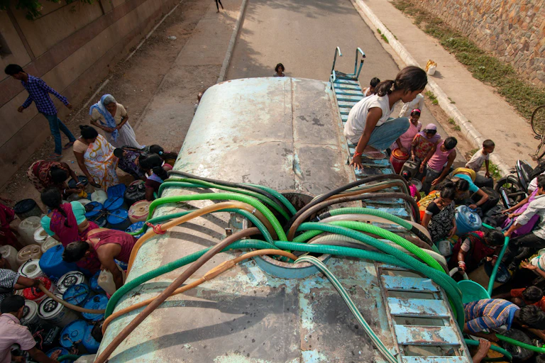 Personas recogiendo agua de un camión cisterna en Nueva Delhi (India).