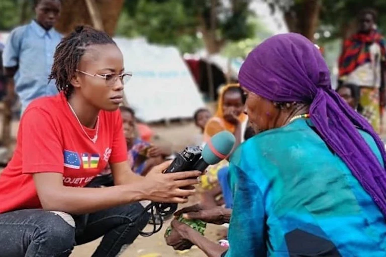 Une journaliste tend un micro à une femme