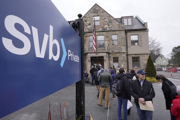Customers queue outside a Silicon Valley Bank branch Wellesley, Massachusetts, March 13, 2023.