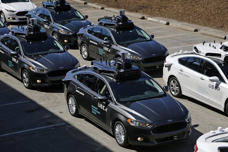 Self-driving Uber cars lined up on a road