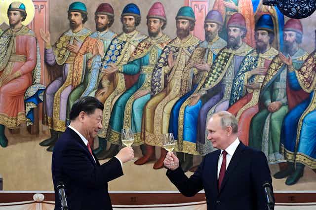 Xi and Putin sharing glasses of wine